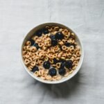 a white bowl filled with cereal and blueberries